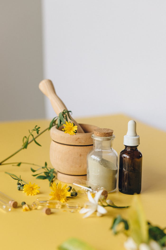hero-img-01 Aromatic herbs with mortar, pestle, and bottles for natural medicine concept.